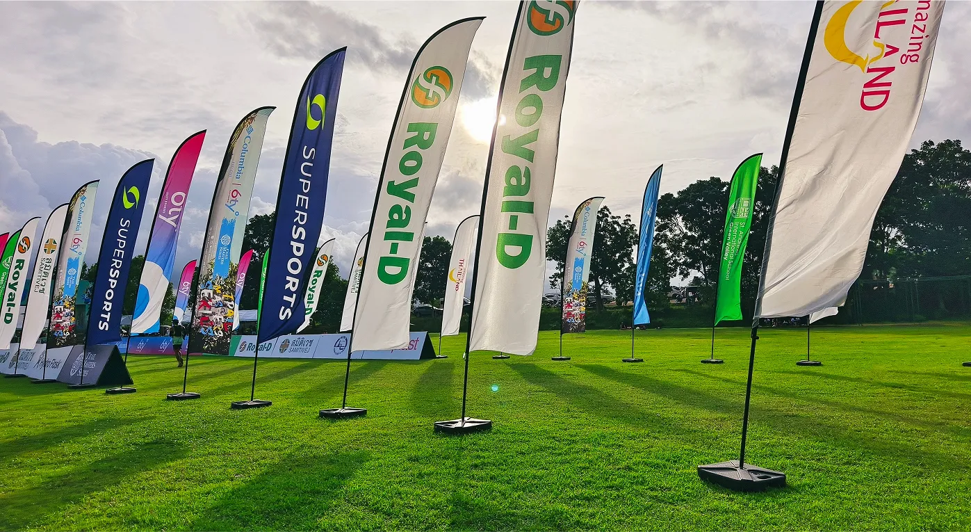 Feather signs promoting sponsors at outdoor event. 
